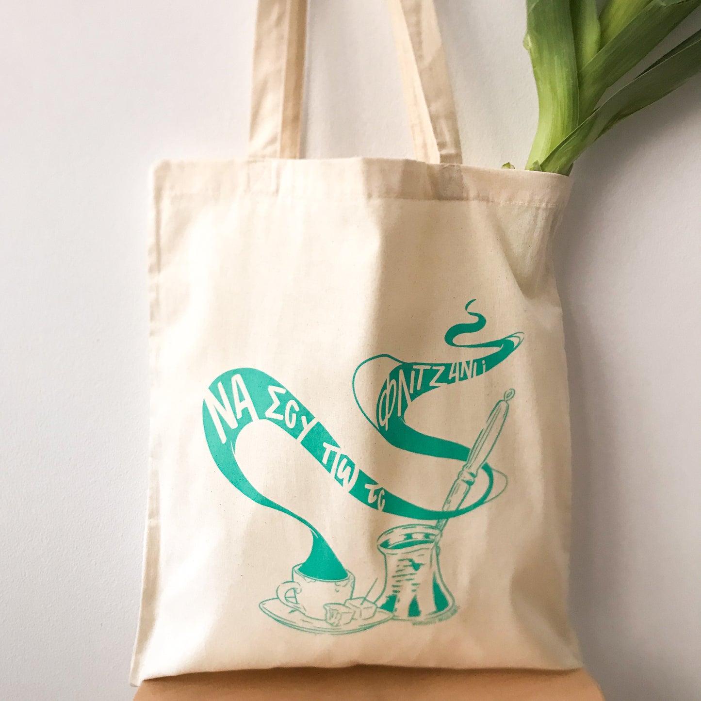 General view of the tote bag with a leek inside.
