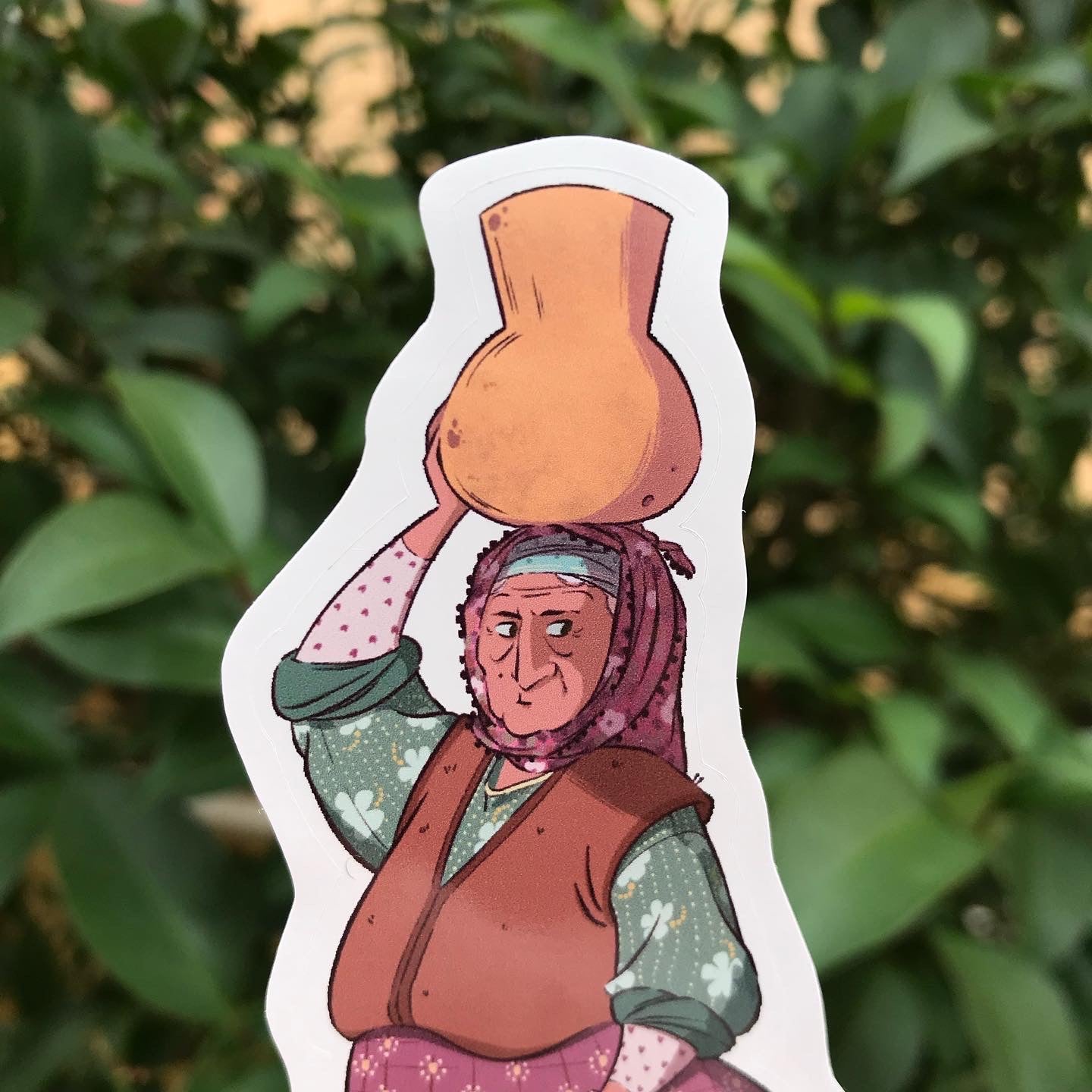 Close up of the upper body of the lady. The background of the picture is a bush.