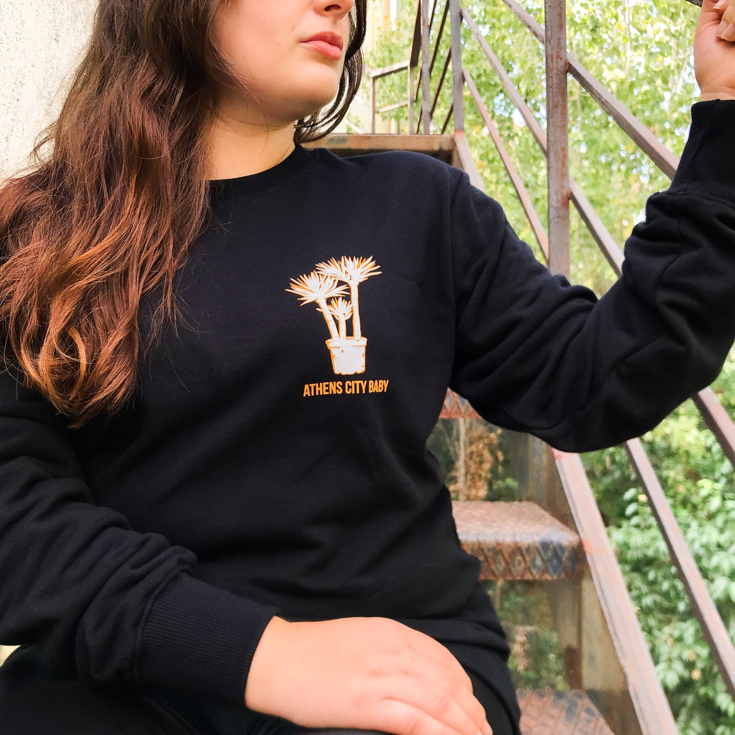 lady sitting on stairs - close up of the front design of the sweatshirt.