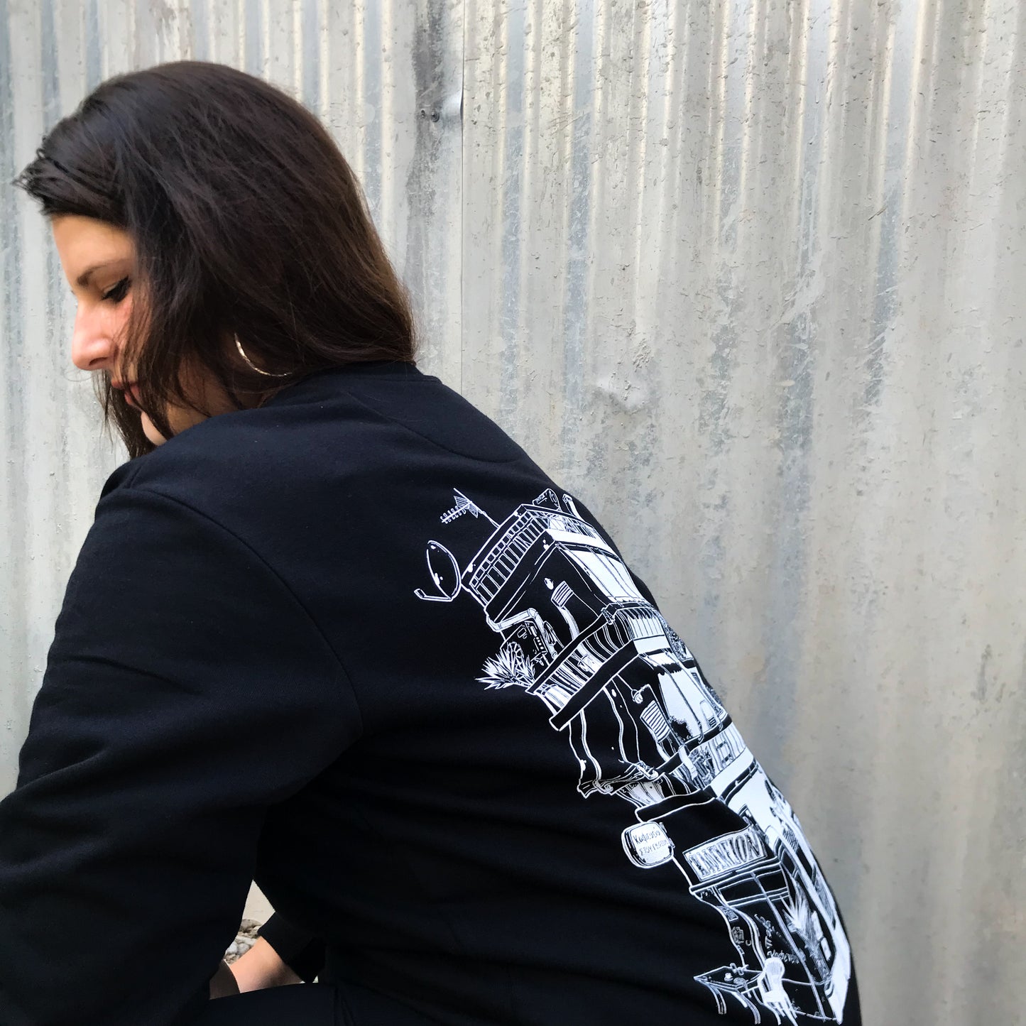 profile of lady sitting with the back design of the sweatshirt visible