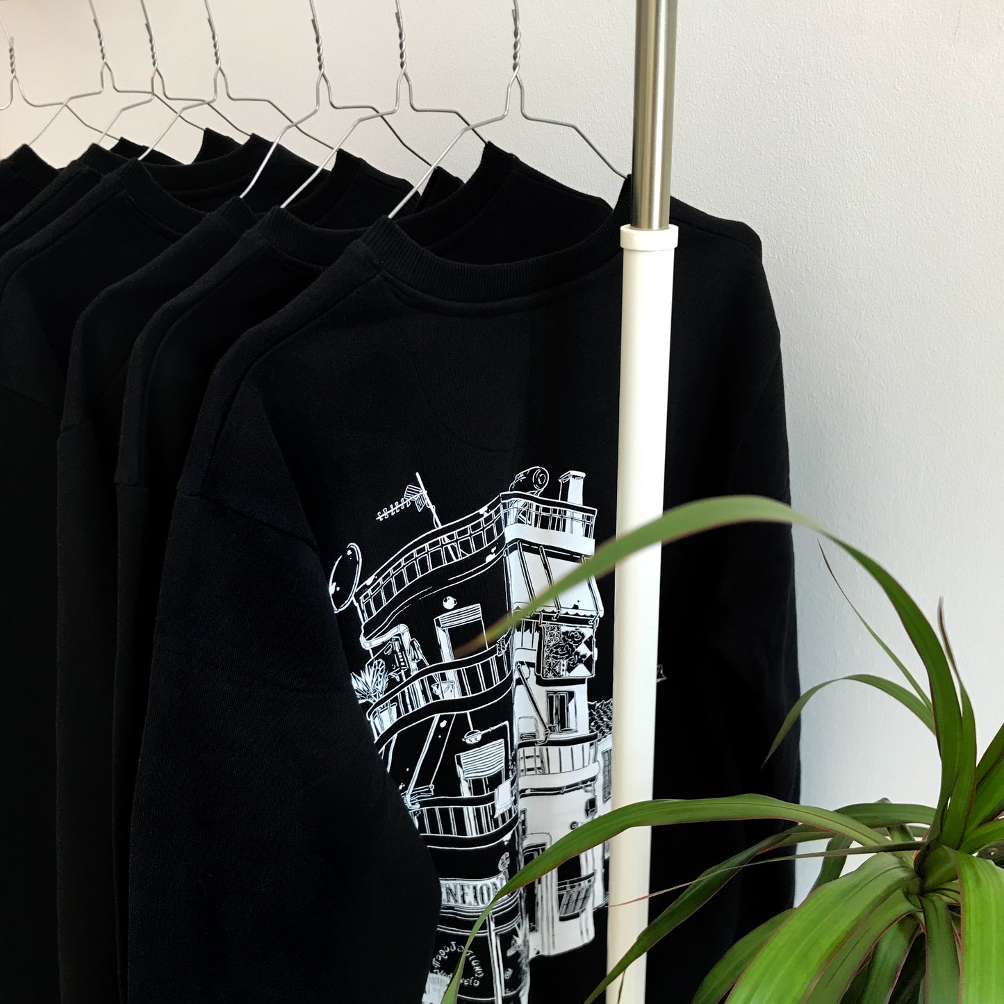 Some of the sweatshirts on hangers.