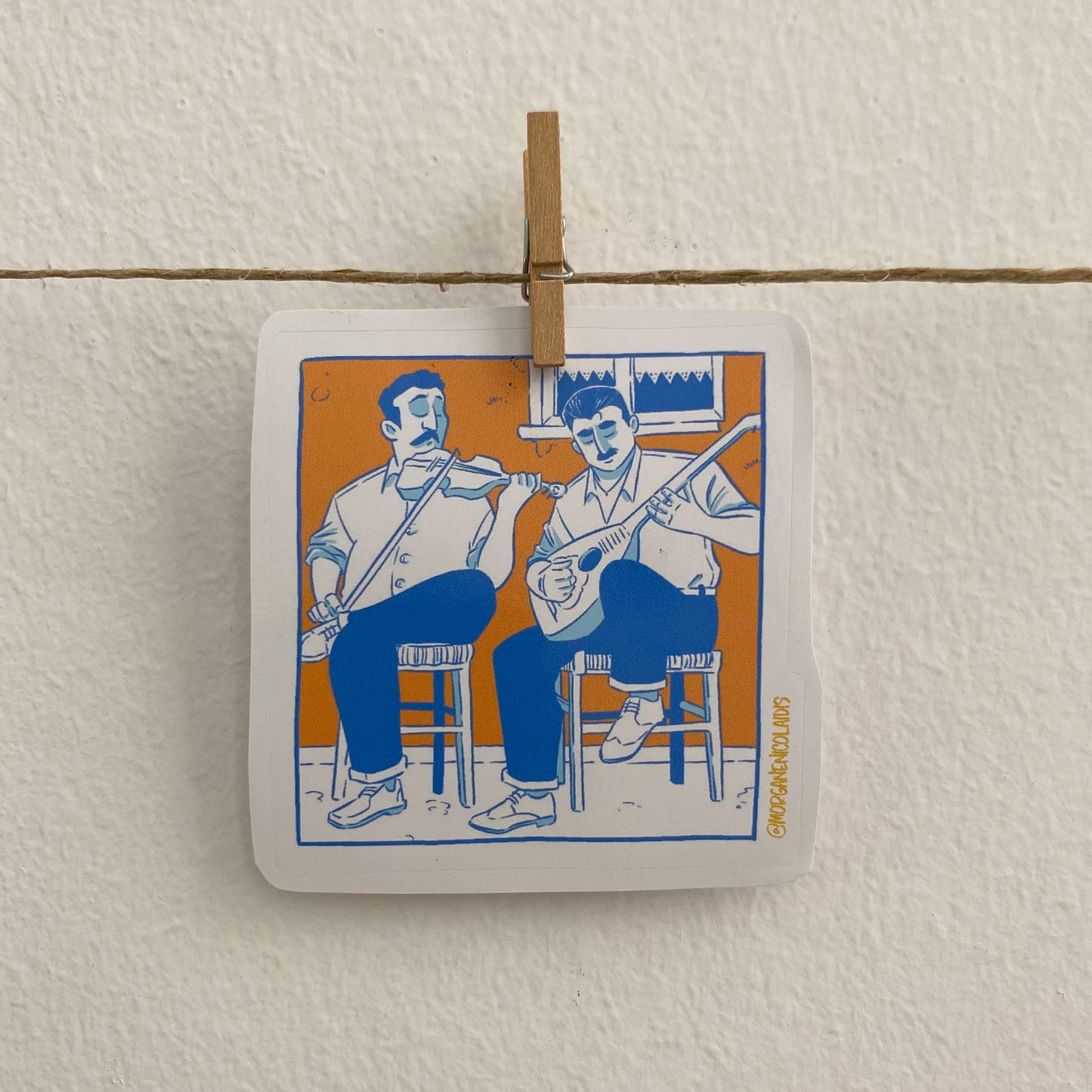 The sticker is hung on a a wire with a clothespin like a clothesline.