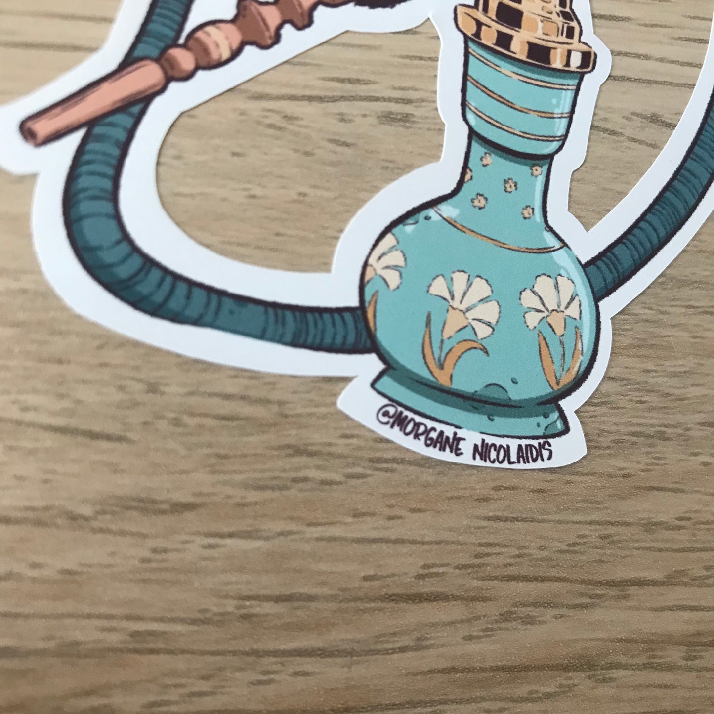 Close up of the botton of the sticker. The glass container is decorated with flowers inspired by the ottoman art.