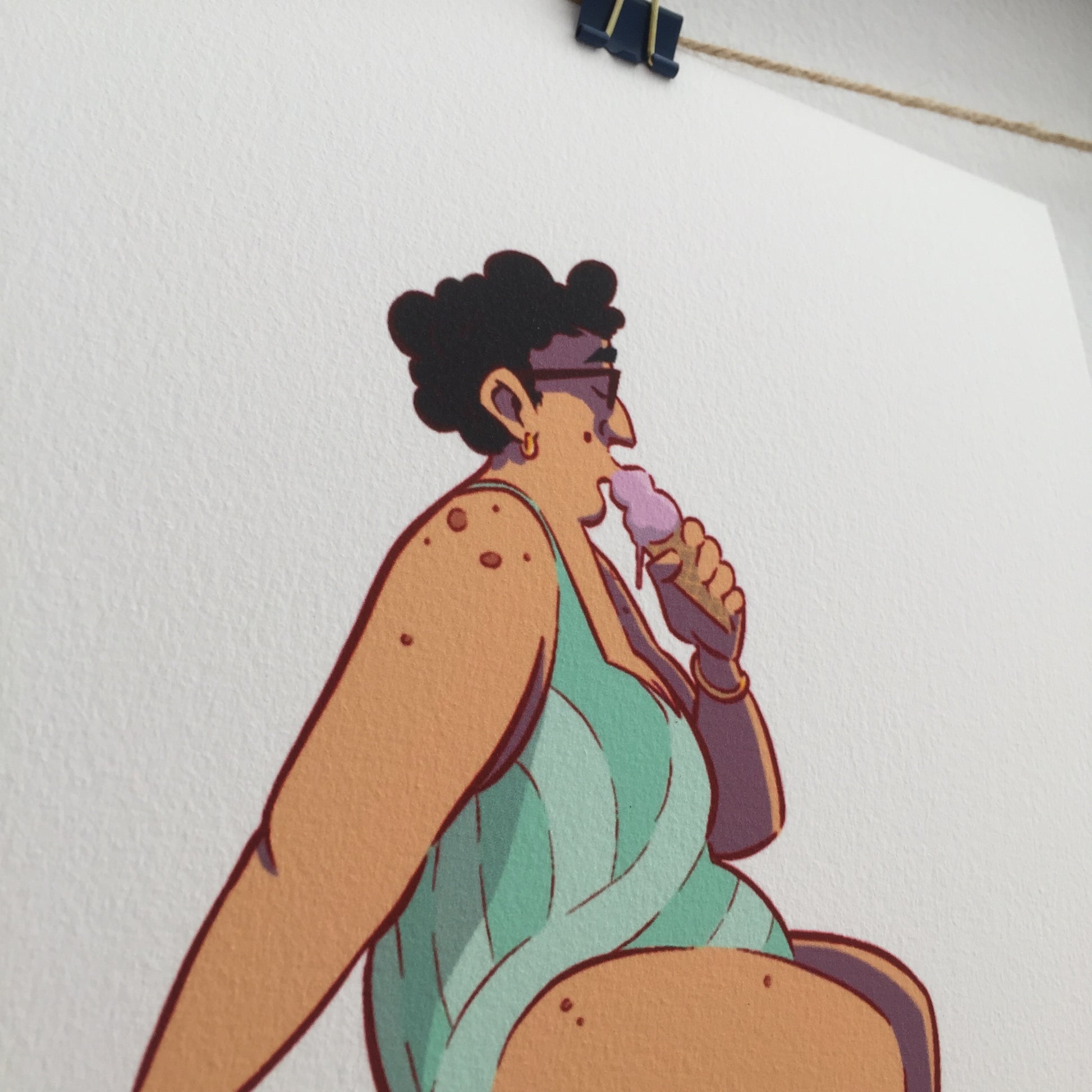 Close up of the lady. The ice cream that she's in eatinf is kind of pink and she's wearing a one piece bathing suit with straps and turquoise colors. She's has golden earings and bracelet.