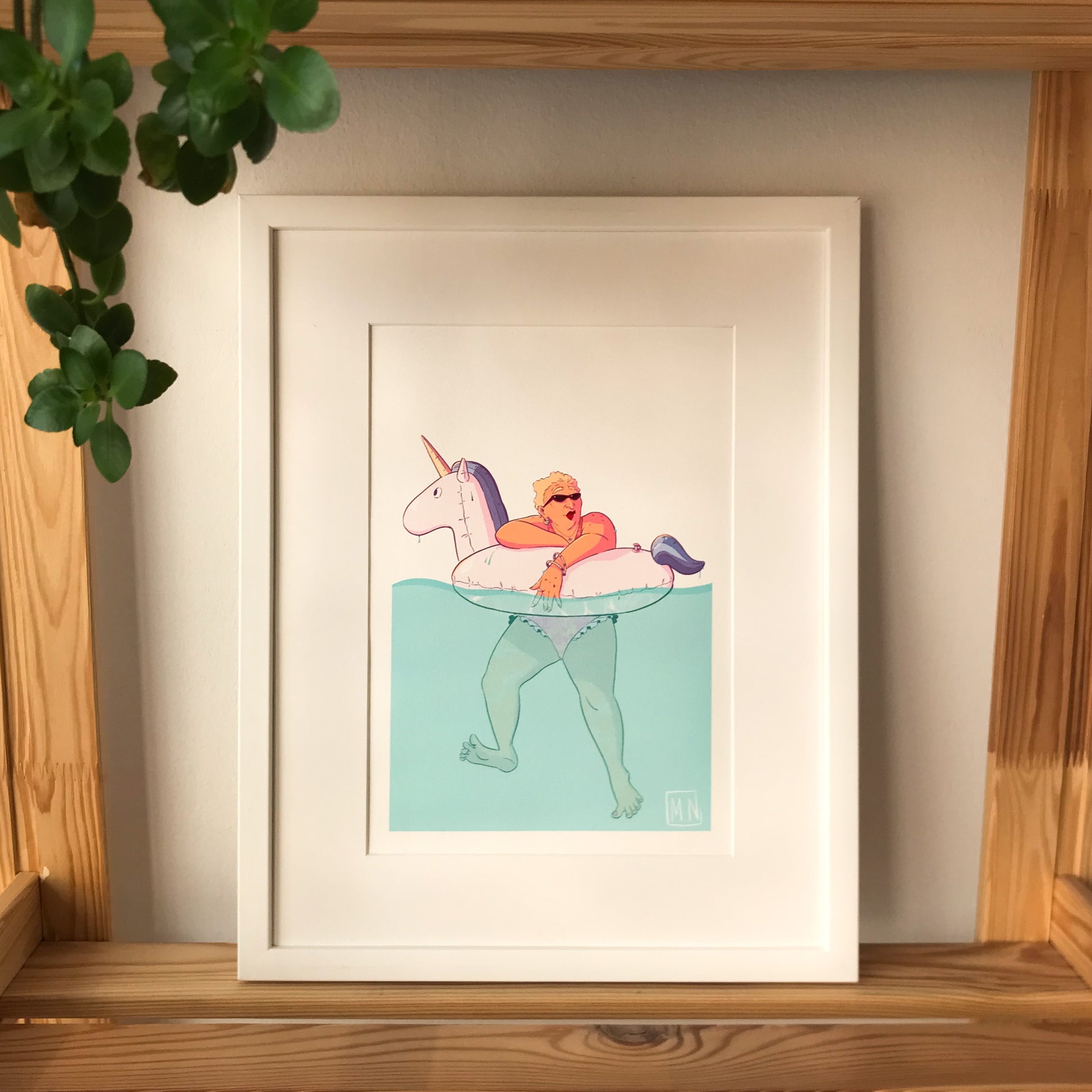 the framed illustration placed on a shelf. 
