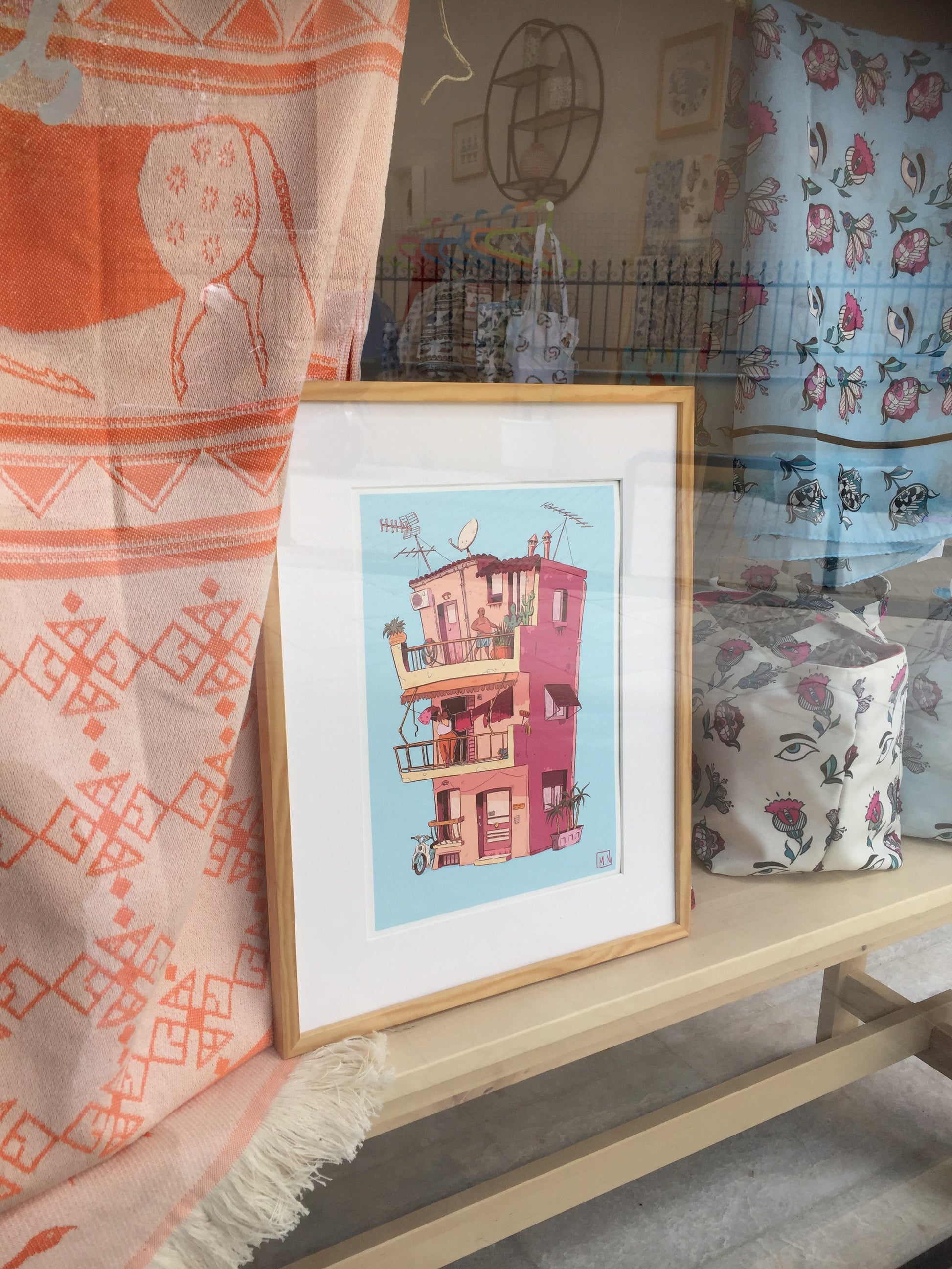 the illustration, framed and placed in a store window.