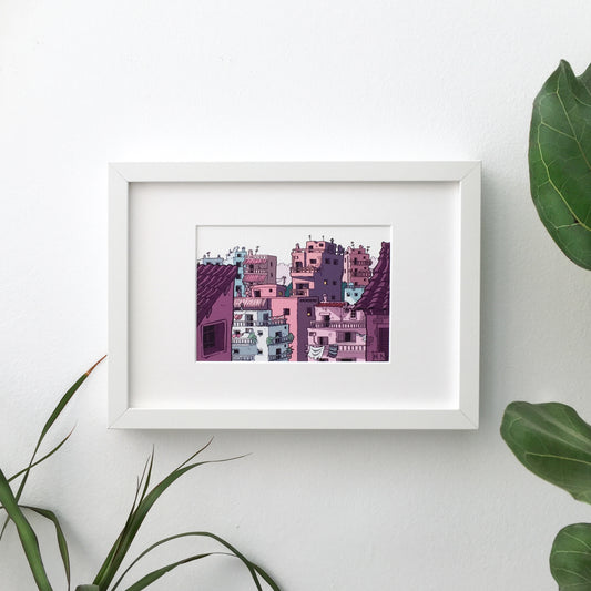 A framed print of Athens in pink version. The print is hang on a white wall and there are a few plants on the ground.